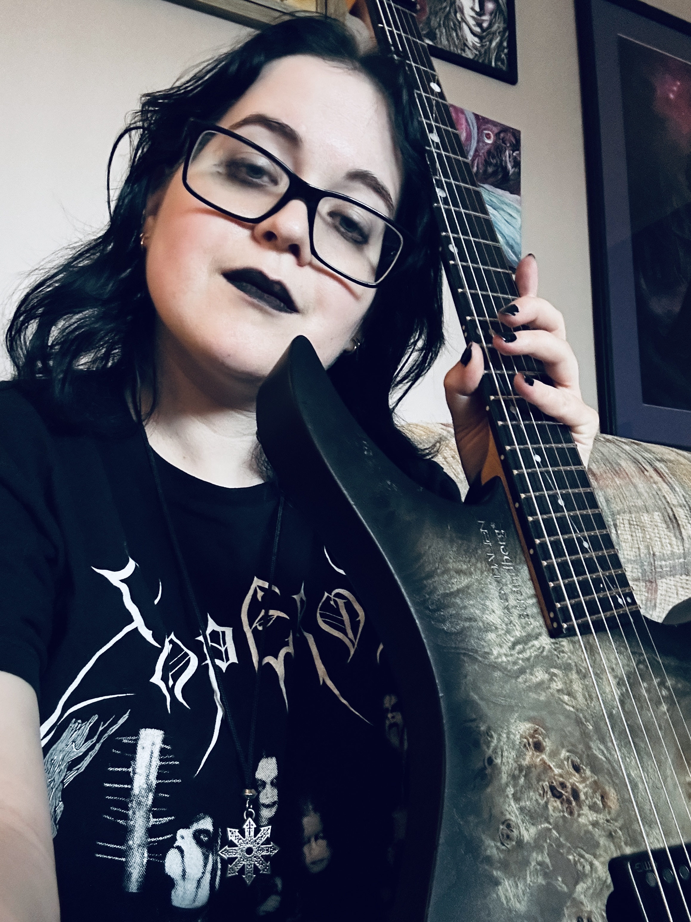 Morgan Argor wearing an Emperor shirt, black lipstick and holding a strandberg guitar.